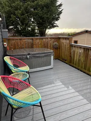 three chairs sitting on a deck with a hot tub at Hafod Shepherd Hut in Aberystwyth
