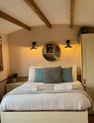 a bedroom with a large bed with a mirror at Hafod Shepherd Hut in Aberystwyth