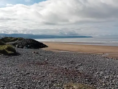 a rocky beach with the ocean in the background at Barmouthbay209 in Barmouth