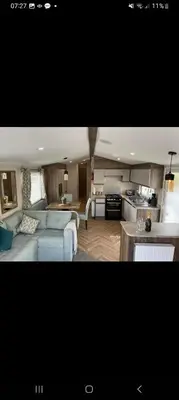 a living room and kitchen with a couch and a table at Barmouthbay209 in Barmouth