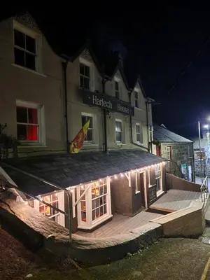 a building with lights on the side of it at night at Harlech House in Harlech