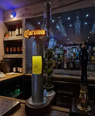 a bar with a drink dispenser in front of a bar at Harlech House in Harlech