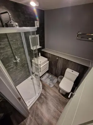 a bathroom with a glass shower and a toilet at Harlech House in Harlech