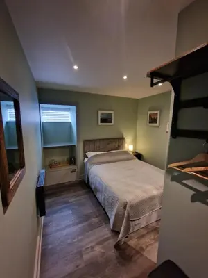a bedroom with a large bed and a window at Harlech House in Harlech