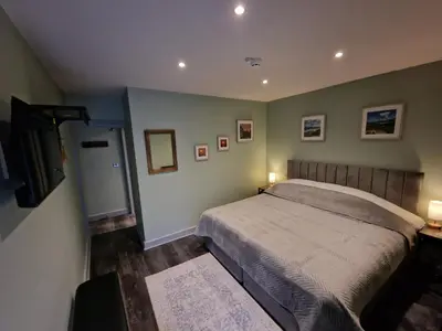 a bedroom with a bed and two lights on at Harlech House in Harlech