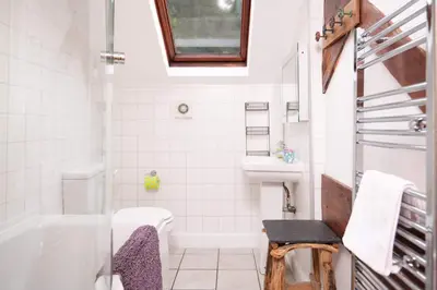 a bathroom with a tub and a toilet and a sink at Ty'r Adar at Graig Wen in Arthog