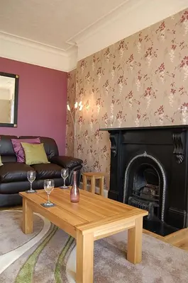 a living room with a couch and a fireplace at Abermaw Sea View Apartment in Barmouth