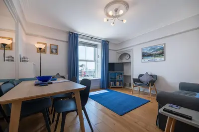 a living room with a table and a couch at Ground Floor Sea View Apartment in Aberdyfi