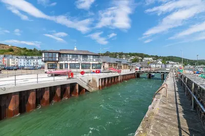 a bridge over a river next to a city at Ground Floor Sea View Apartment in Aberdyfi