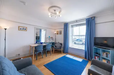 a living room with a couch and a table with a blue rug at Ground Floor Sea View Apartment in Aberdyfi