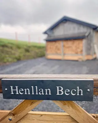 a sign that reads henlinelin beach on a wooden bench at Glyndwr Way Cabin in Machynlleth