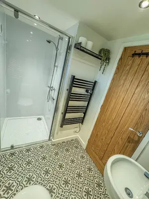 a bathroom with a shower and a toilet and a sink at Glyndwr Way Cabin in Machynlleth