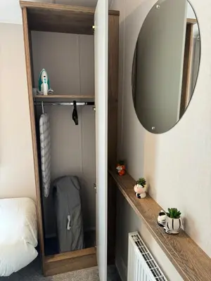 a room with a mirror and a shelf with a bag at Sea La Vie Lodge in New Quay