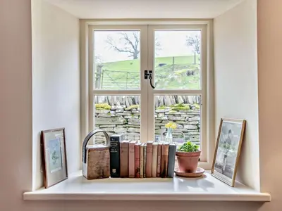 a window with books on a shelf in front of a window at 3 Bed in Brecon oc-94434 in Velindre