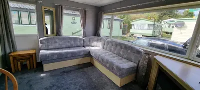 a couch sitting in a room with a window at Seaside View Holiday Home in Aberystwyth