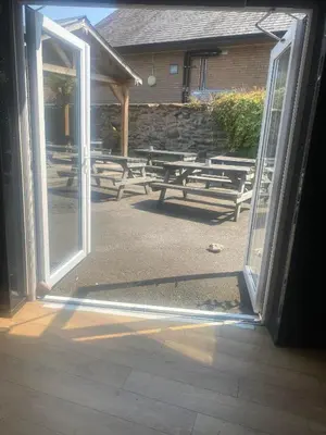 an open door with a bunch of picnic tables behind it at Prince of wales pub and accommodation in Llangollen