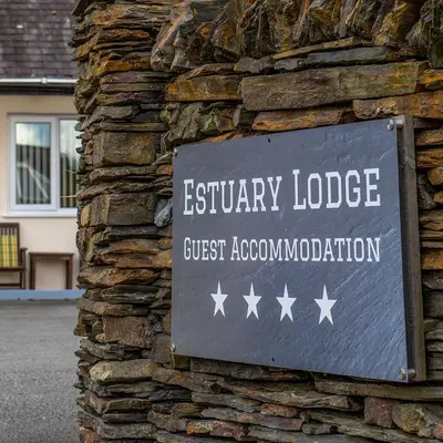 a sign on the side of a stone building at Estuary Lodge Motel in Talsarnau