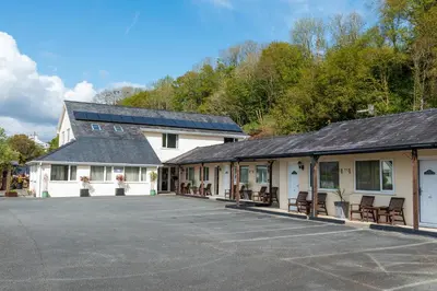 a building with a parking lot in front of it at Estuary Lodge Motel in Talsarnau