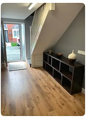 a living room with a staircase and a vase on a shelf at The Little House, Oswestry in Oswestry