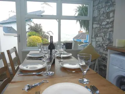 a table with a bottle of wine and glasses on it at 3 Prospect Place New Quay in New Quay