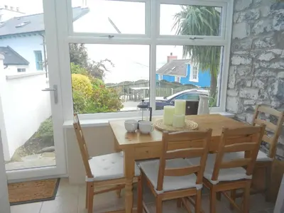 a dining room with a table and chairs and a window at 3 Prospect Place New Quay in New Quay