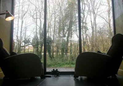 a room with two chairs and a large window at Creatively converted barn in accessible rural spot in Llanwrda