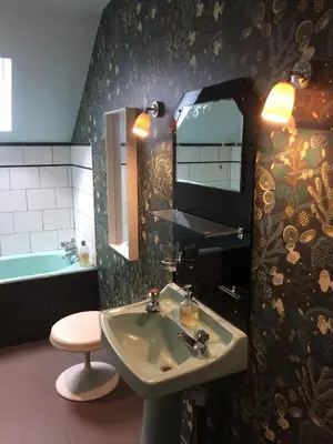 a bathroom with a sink and a mirror and a tub at Creatively converted barn in accessible rural spot in Llanwrda
