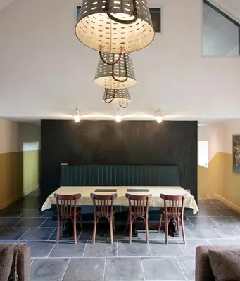 a dining room with a table and chairs and a chandelier at Creatively converted barn in accessible rural spot in Llanwrda