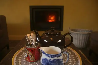 a tea pot and a cup of coffee on a table at Creatively converted barn in accessible rural spot in Llanwrda