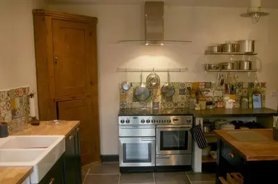 a kitchen with a stove and a sink at Creatively converted barn in accessible rural spot in Llanwrda