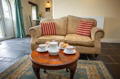 a living room with a couch and a coffee table at The Coach House New Quay in Cross Inn