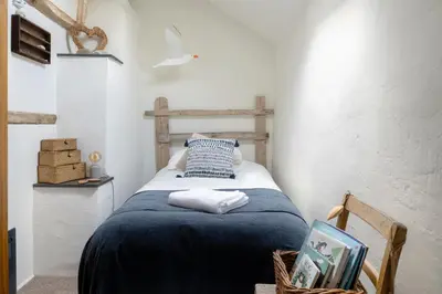 a bedroom with a bed with a blue blanket at Pen-Y-Bryn Cottage in Blaenau-Ffestiniog