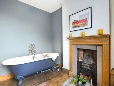 a bath tub in a bathroom with a fireplace at The Haven in Ludlow