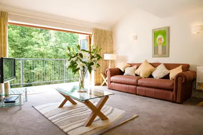 a living room with a couch and a glass table at Hay Retreats in Hay-on-Wye