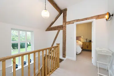 a room with a staircase and a bedroom with a bed at The Hop Kiln in Leominster