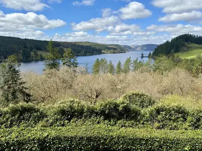 a view of a lake with trees in the distance at 1 Bed in Llanfyllin oc-p29023 in Llanfyllin