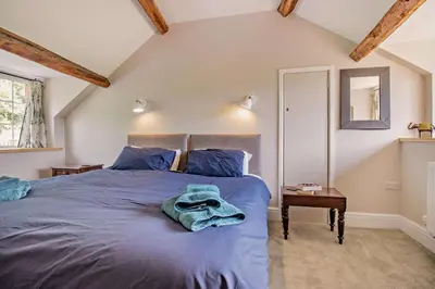 a bedroom with a bed with blue sheets and a mirror at 3 Bed in Cemmaes Road oc-h29101 in Cemmaes