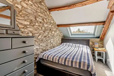 a bedroom with a bed and a stone wall at 2 Bed in Cross Inn oc-t29117 in Cross Inn