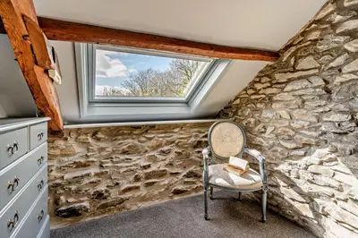 a stone walled room with a chair and a window at 2 Bed in Cross Inn oc-t29117 in Cross Inn
