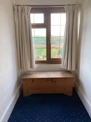 a room with a window with a bench in front of it at Bryntirion Farmhouse Rooms (with bathroom) in Llanfair Caereinion