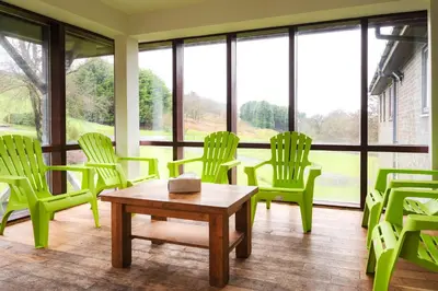a waiting room with green chairs and a table at Rural Group Lodging 19 rooms 83 beds Games room in Elerch