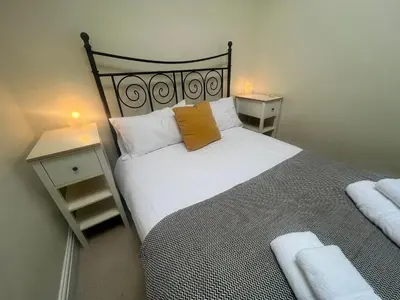a bedroom with a large bed with two night stands at Nant Meigan, Georgian Townhouse in centre of Aberaeron, dog friendly in Aberaeron