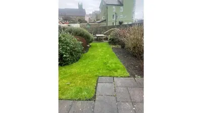 a garden with green grass and a pathway at Nant Meigan, Georgian Townhouse in centre of Aberaeron, dog friendly in Aberaeron