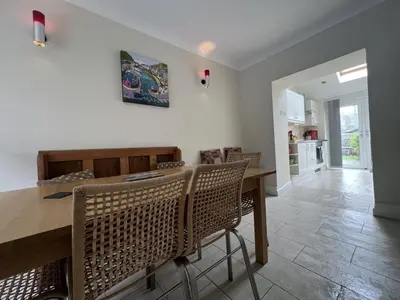 a dining room with a wooden table and chairs at Nant Meigan, Georgian Townhouse in centre of Aberaeron, dog friendly in Aberaeron