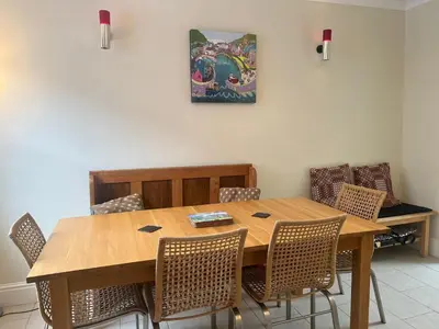 a dining room table with chairs and a painting on the wall at Nant Meigan, Georgian Townhouse in centre of Aberaeron, dog friendly in Aberaeron