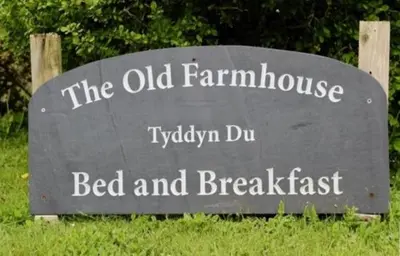 a sign for the old farmhouse bed and breakfast at The Old Farmhouse B&B in Dyffryn