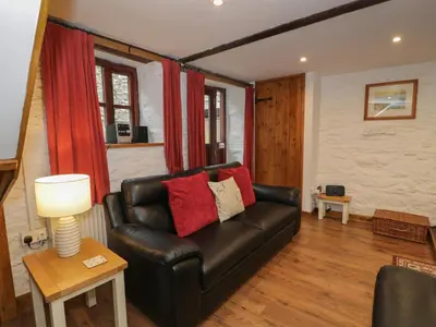 a living room with a leather couch and a table at Graig Las The Barn in Oswestry