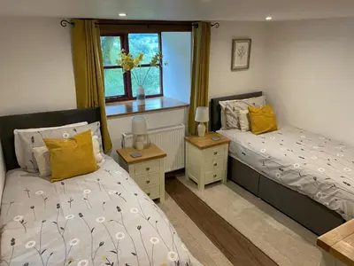 a bedroom with two beds and a window at Graig Las The Barn in Oswestry