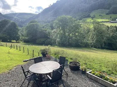 a table and chairs with a view of a field at Graig Las The Barn in Oswestry
