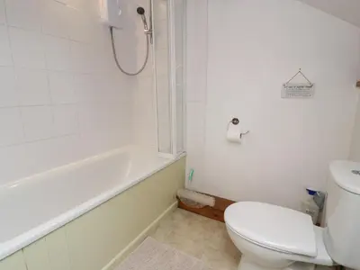 a bathroom with a toilet and a tub and a sink at Graig Las The Barn in Oswestry